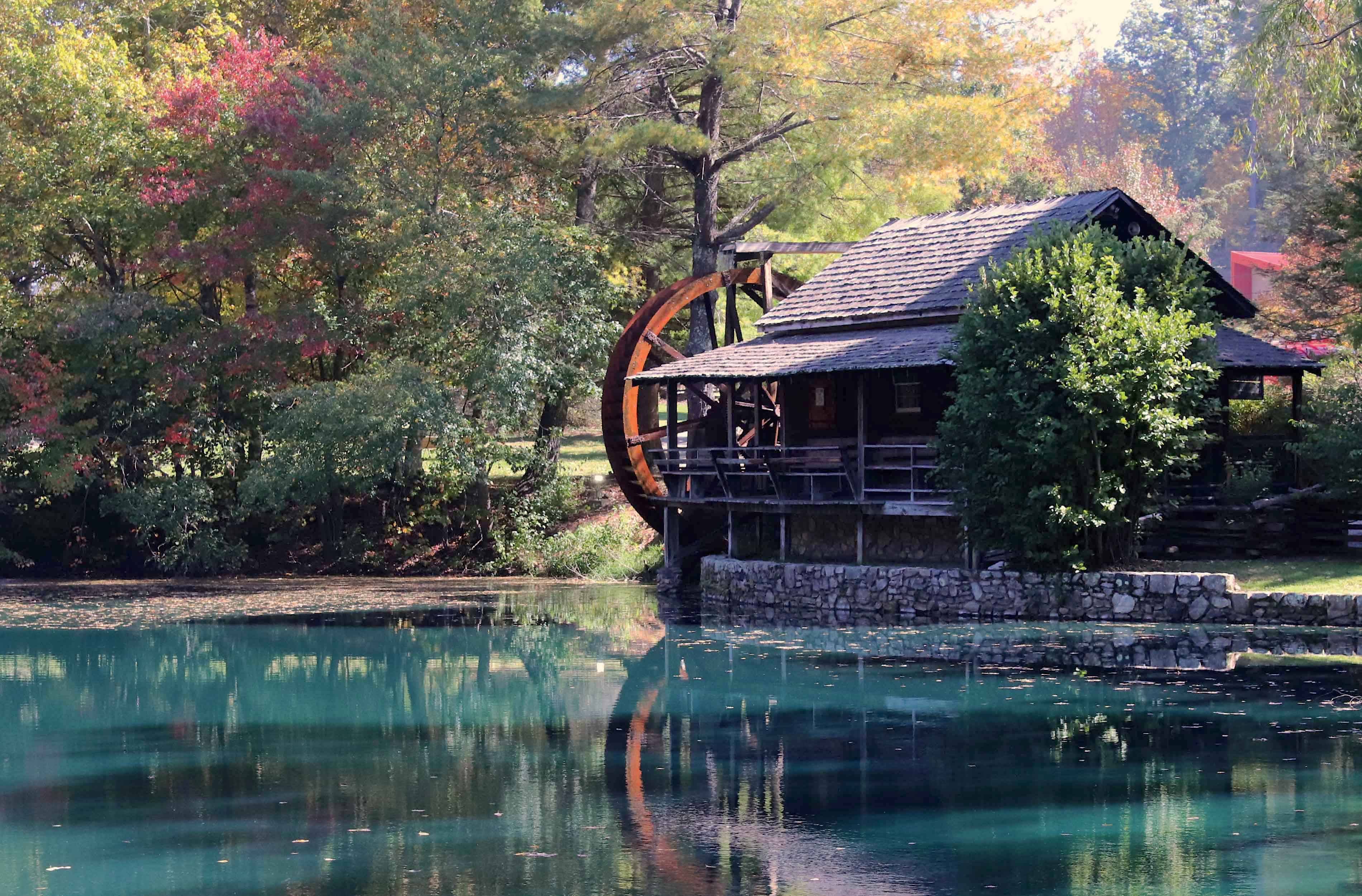 millpond in the fall with teal water and green trees